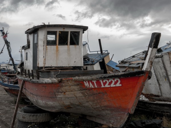Trosky rybářských lodí v Puerto Natales